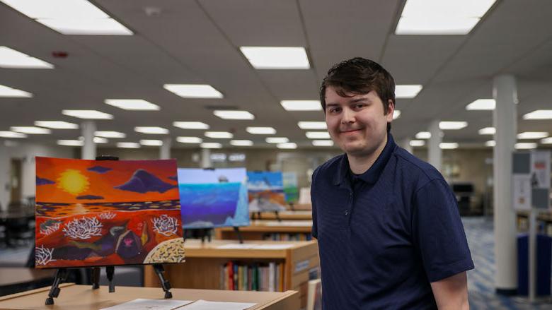 Jacob Campbell standing next to his painting